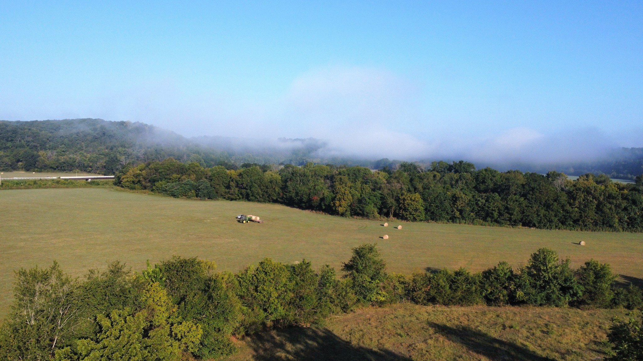 Morning fog drifting across fields and wooded hills near Kindling Trail Cabin